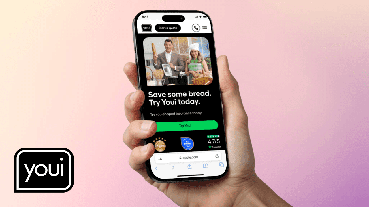 Hand holding mobile phone displaying the Youi website
